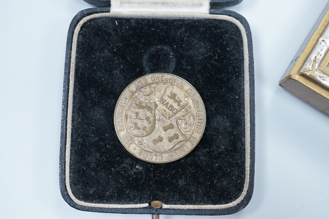 Framed group of eight WWI and WWII medals including a First World War medal pair, the Africa star, the Atlantic star, etc. a hallmarked silver boxing medal and another, both cased, plus a Lancashire and Cheshire Associat